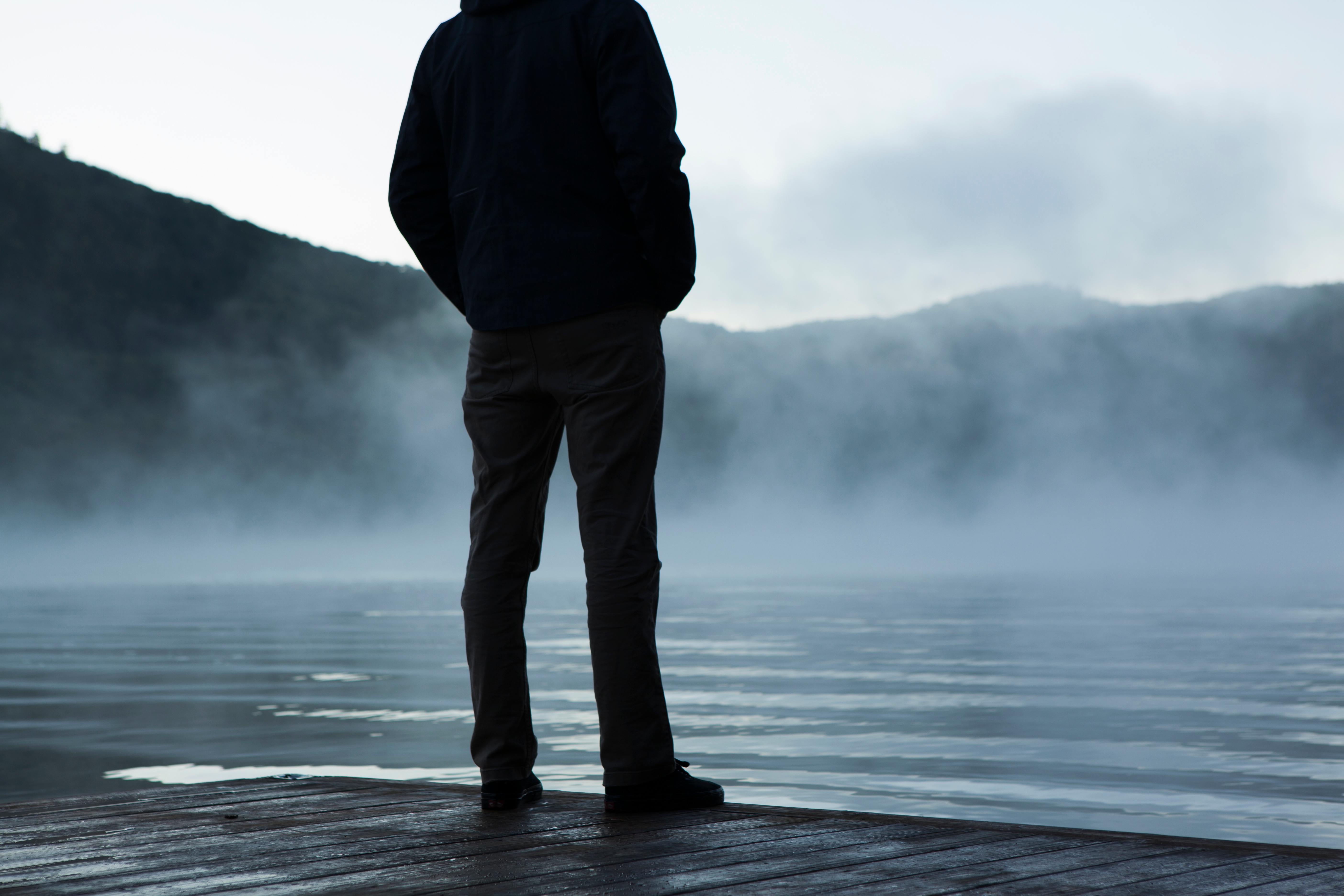 Indistinct man looking at a steaming lake